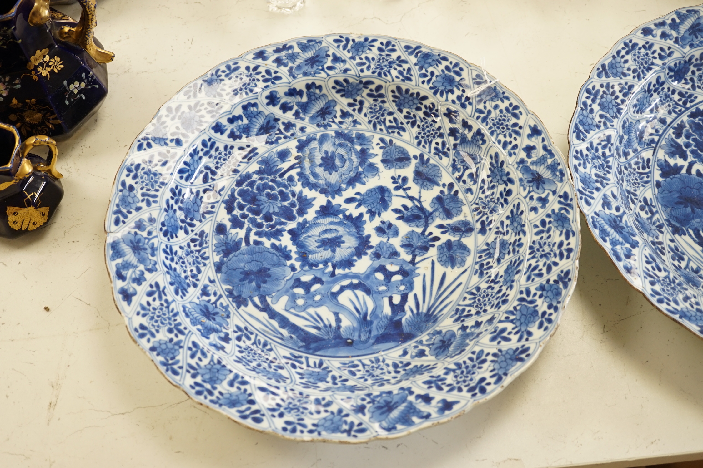 A pair of Chinese Kangxi blue and white dishes, painted with rock work and flowers, artemisia leaf marks, 37cm diameter